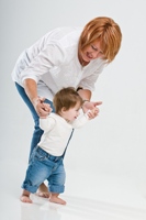 Mother helping toddler learn to walk